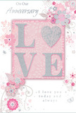 This image shows a beautifully crafted anniversary card, imagined as if propped beside a hand-tied bouquet in a Tolworth florist window. At the heart of the design, the word "LOVE" stretches across the centre in raised, glitter-touched letters. The colours shift between blush pink, creamy white and soft silver, so the word seems to shimmer softly, like petals lit by gentle daylight streaming through a shopfront on Ewell Road. The glitter appears fine and evenly applied, giving a refined sparkle and a lightly textured feel that would be pleasant to touch. Surrounding this central word is a flowing border of stylised flowers and leaves, all set against a muted pink background. The blossoms are drawn with delicate lines and subtle shading in blush, ivory and pale grey, evoking the look of a florist's detailed sketch for a romantic anniversary arrangement. They cluster in loose sprays and gentle arcs, suggesting the relaxed elegance of bouquets delivered across Tolworth to mark special milestones. Slender vines curl between the flowers, while small leaves and tiny decorative flourishes add rhythm and movement, much like the natural fall of foliage in a well-balanced design. Here and there, hints of silver accentuate edges and details, catching the light without overwhelming the card's soft, pastel character. The anniversary message, penned in an elegant script, curves gracefully among the floral forms, echoing the fluidity of petals and tendrils. Soft, even lighting enhances the overall warmth of the scene, highlighting the blush-pink tones and the delicate interplay between matte background and glittering text. The result is a card that feels gentle, romantic and deeply personal-an ideal accompaniment to fresh flowers when celebrating an enduring love story in Tolworth.